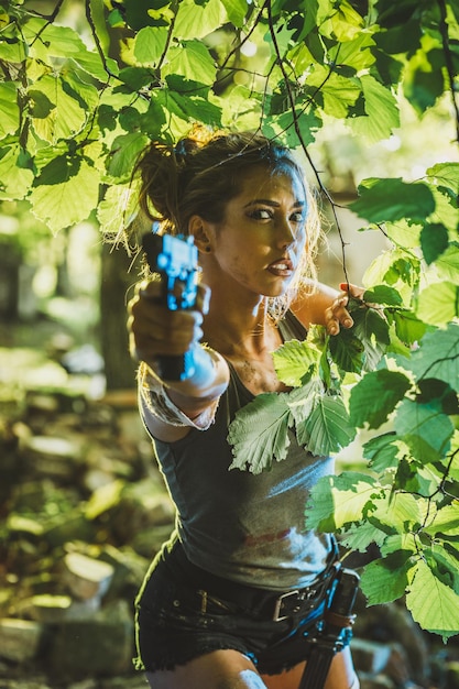 A Woman Holding a Gun in a Forest