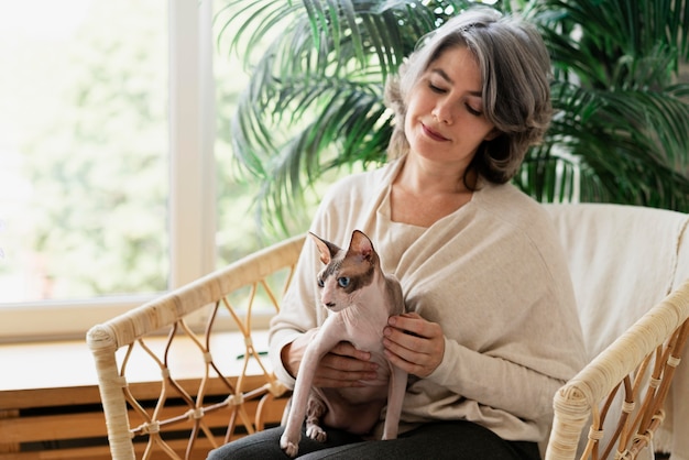 Photo woman holding hairless cat medium shot