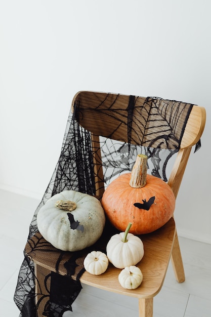 Woman holding halloween pumpkin with spider on a chair