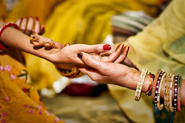 Woman holding hand of bride during wedding ceremony