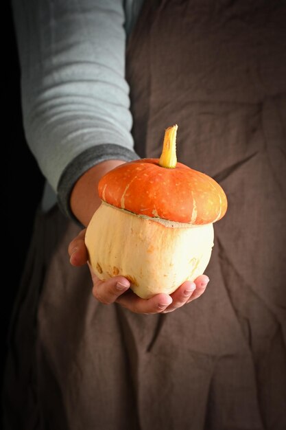 Woman holding in hand freshly pumpkin closeup