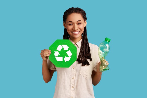 Woman holding in hand recycling sign board and plastic bottle garbage sorting