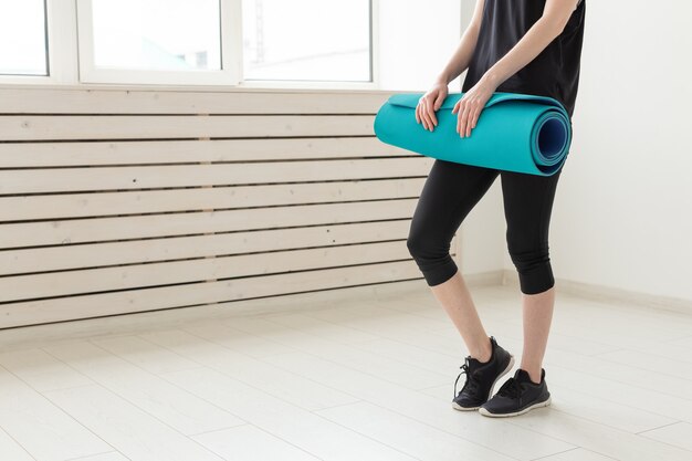 Woman holding in hand a sports mat