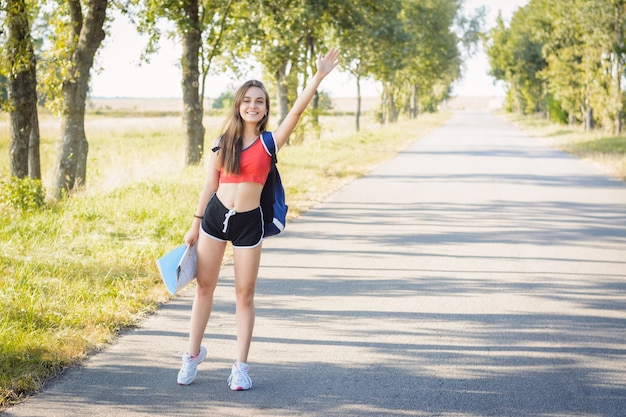 Woman holding a hand up hitchhiking