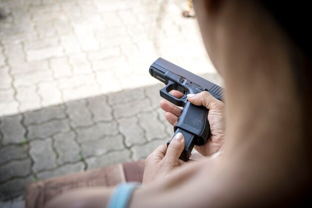 Photo woman holding handgun on footpath