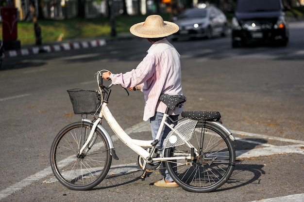 Photo woman holding a handle bar bike crossing crosswalk on street