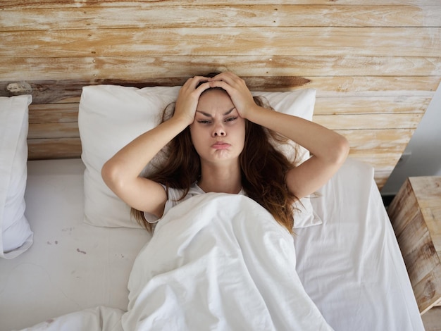 woman holding hands poured antics lying in bed morning High quality photo