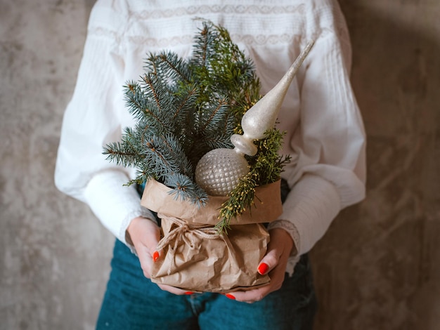 写真 手を繋いでいる女性ライトの花輪とガラス ファイル クラフト ペーパーで飾られた小さなクリスマス ツリー