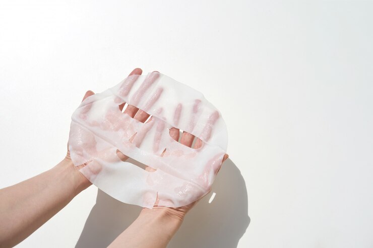 Photo 白い壁に使用する準備ができて手ティッシュマスクを保持している女性