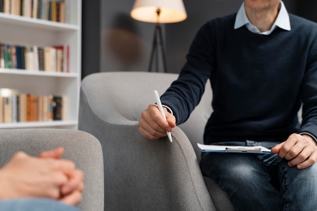 Photo woman holding hands together talking with therapist