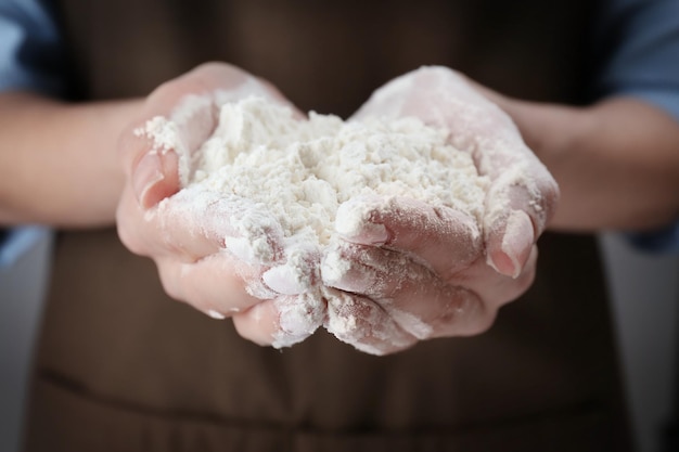 Woman holding heap of flour in hands closeup