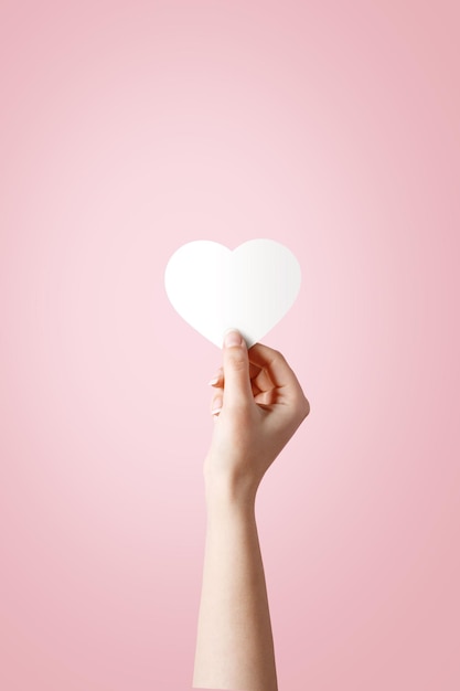 Woman holding heart shape over white background