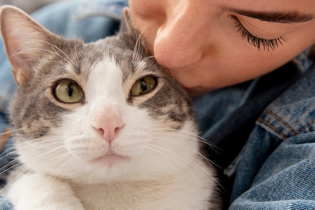 Photo woman holding her adorable kitty indoors