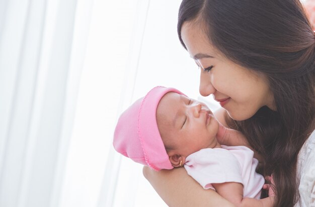 Woman holding her baby girl, close up