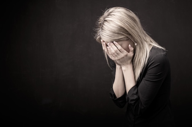 Woman holding her face in her hands