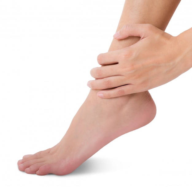 Woman holding her foot and massaging ankle in pain area isolated on white