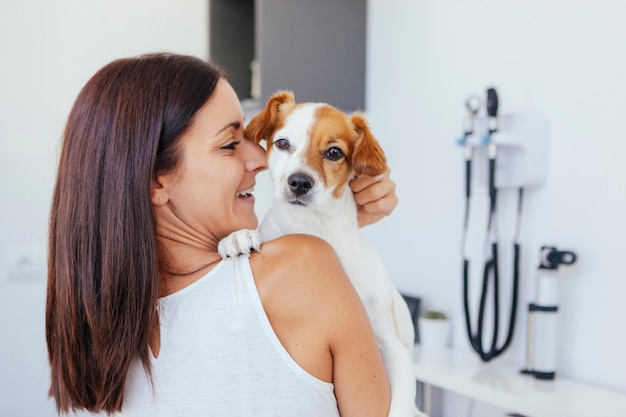 Woman holding her healthy dog in a clinic