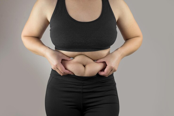 Photo woman holding her own belly fat close up of young woman suffering from belly fat