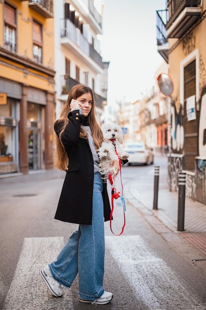 Woman holding her puppy while calling a friend