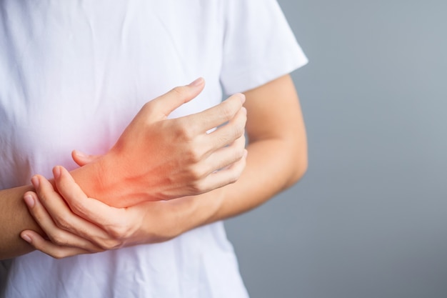 Woman holding her wrist pain because using smartphone or computer long time. De Quervain's tenosynovitis, Intersection Symptom, Carpal Tunnel Syndrome or Office syndrome concept