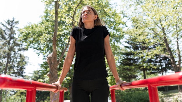 Woman holding herself on two metal bars