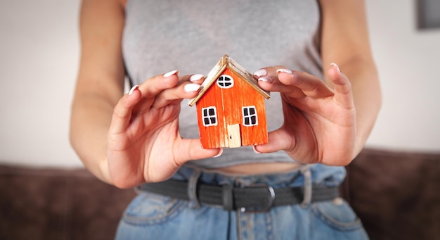 Woman holding house model at home.