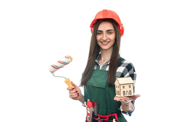 Woman holding house model and roller isolated on white