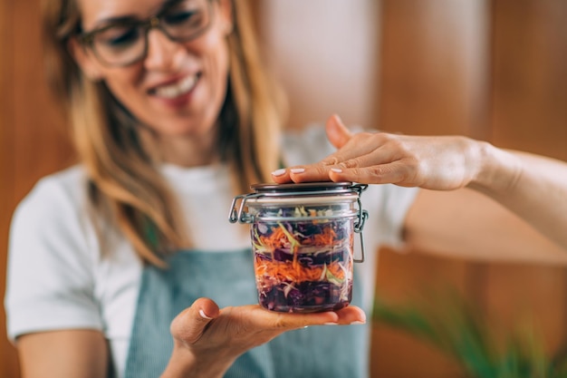 Woman Holding a Jar with Fermented Vegetables