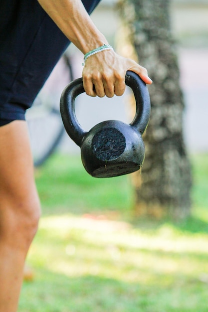 Photo woman holding a kettlebell at an outdoor functional workout