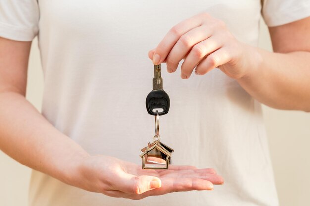 Woman holding a key with keychain in the shape of the house