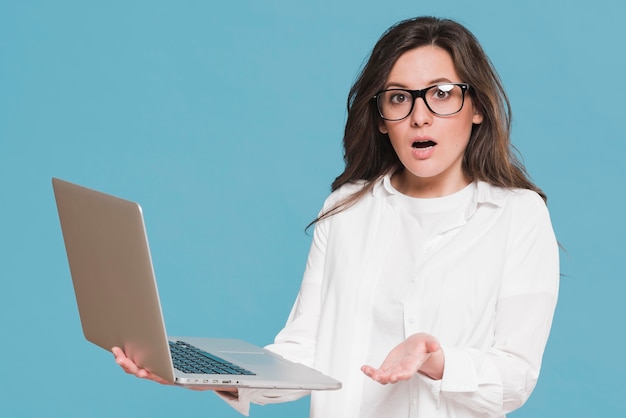 Photo woman holding a laptop and being surprised