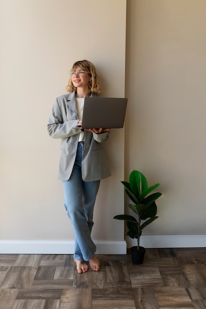 Woman holding laptop full shot