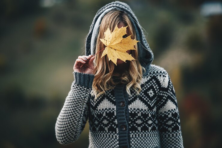 Photo woman holding leaf while standing outdoors