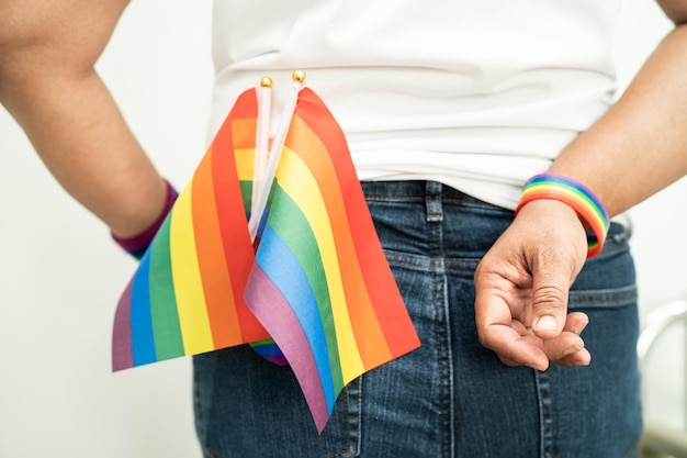 Woman holding LGBT rainbow colorful flag symbol of lesbian gay bisexual transgender human rights tolerance and peace