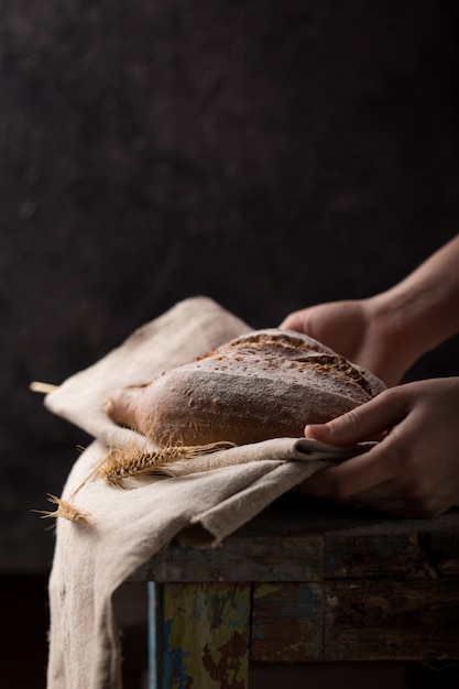 Фото Женщина, держащая буханку хлеба.