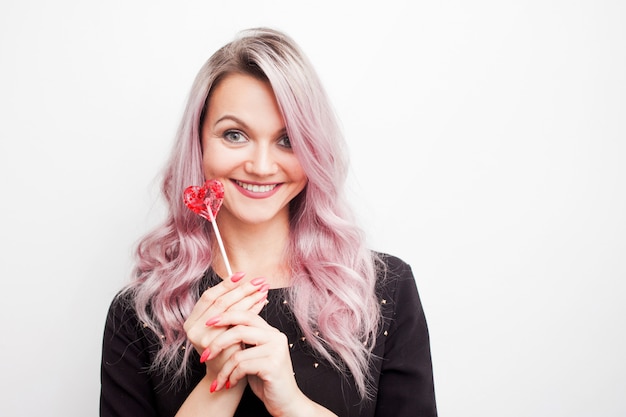 Woman holding a lollipop in the form of heart