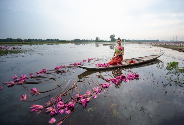 Woman Holding Lotus While Sitting On Boat In Lake 