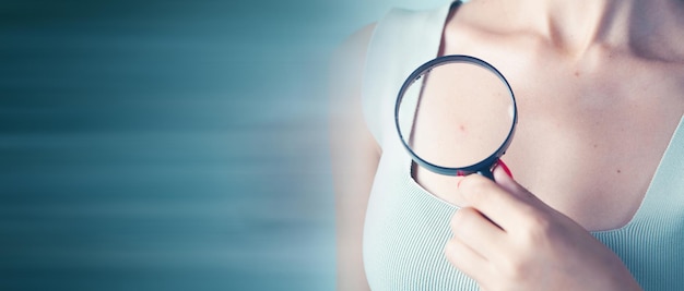 Woman holding a magnifying glass. pimple on the body