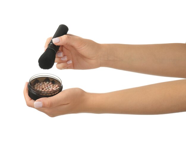 Woman holding makeup brush with powder balls on white