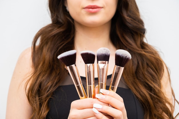 Woman holding makeup brushes in hands