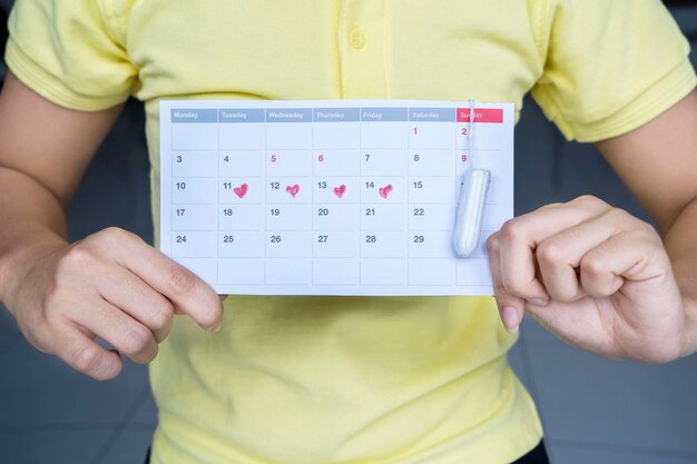 Foto donna con un calendario mestruale e un tampone