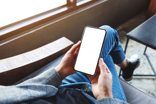  of a woman holding mobile phone with blank white desktop screen