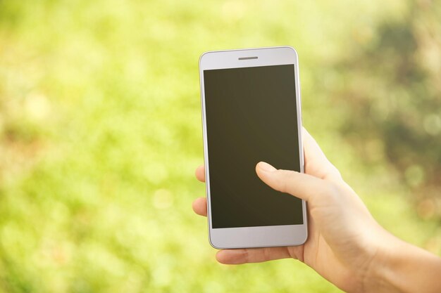 Woman holding modern cellphone outdoor