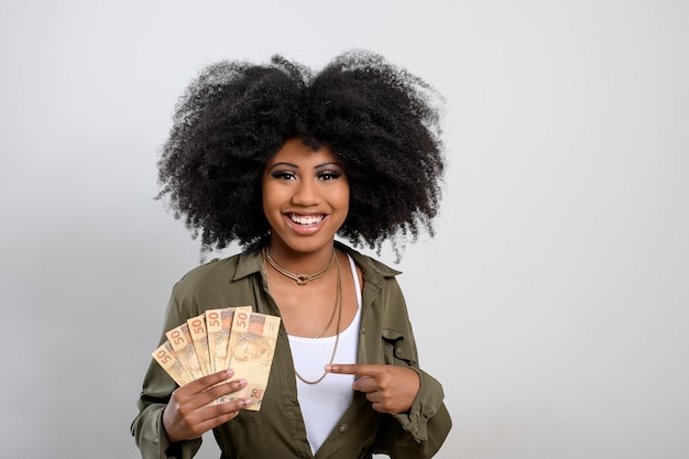 Woman holding money brazilian money on gray background