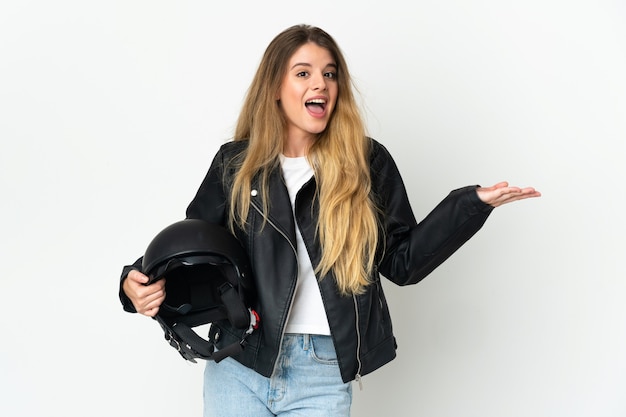 충격 된 표정으로 흰색 배경에 고립 된 오토바이 헬멧을 들고 여자