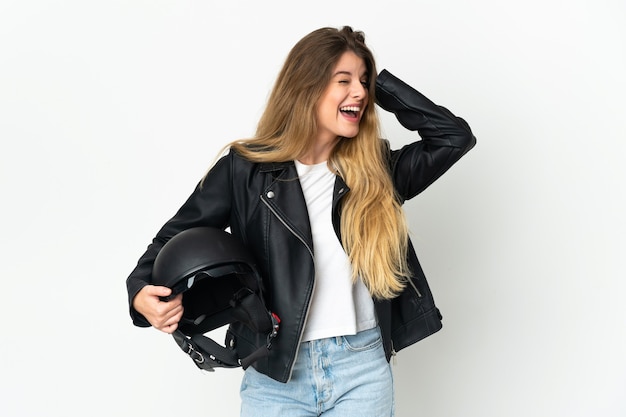 Woman holding a motorcycle helmet posing isolated against the blank wall