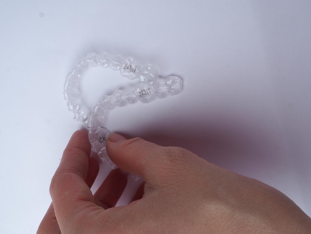 Woman holding mouthguard on white