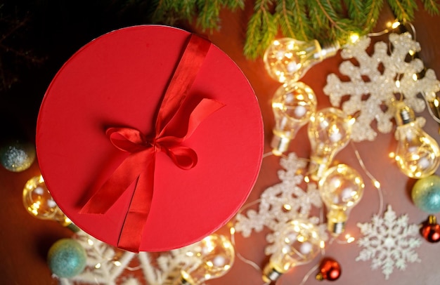 Woman holding node christmas gifts laid on wooden table background