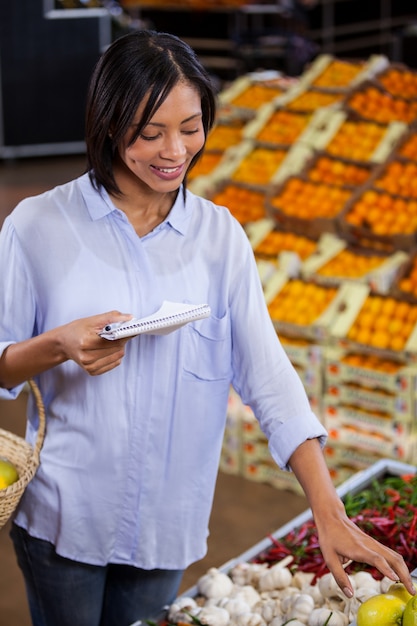 Woman holding notepad while shopping