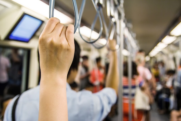 Woman holding onto a handle on a train